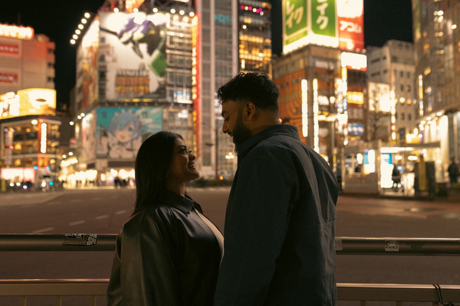 Piratheepan and Shivanna silhouetted against a neon-lit Tokyo intersection at night